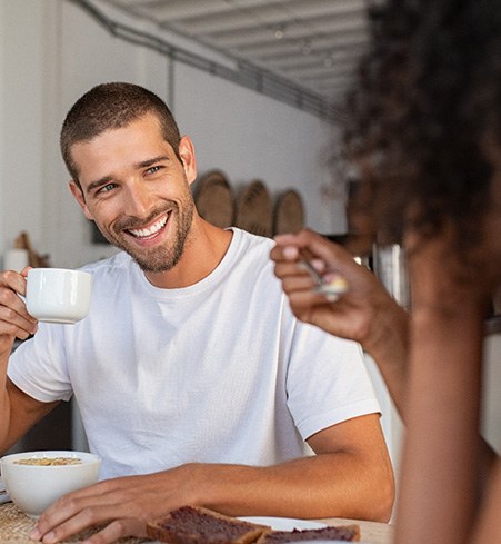 Man smiling while enjoying coffee at home