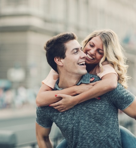 Man and woman smiling after adult orthodontic treatment