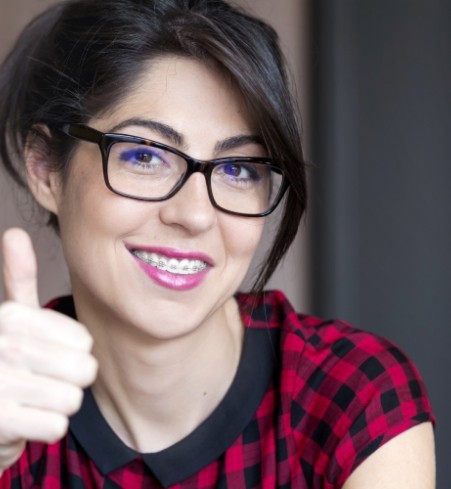 Woman with adult orthodontics giving a thumbs up
