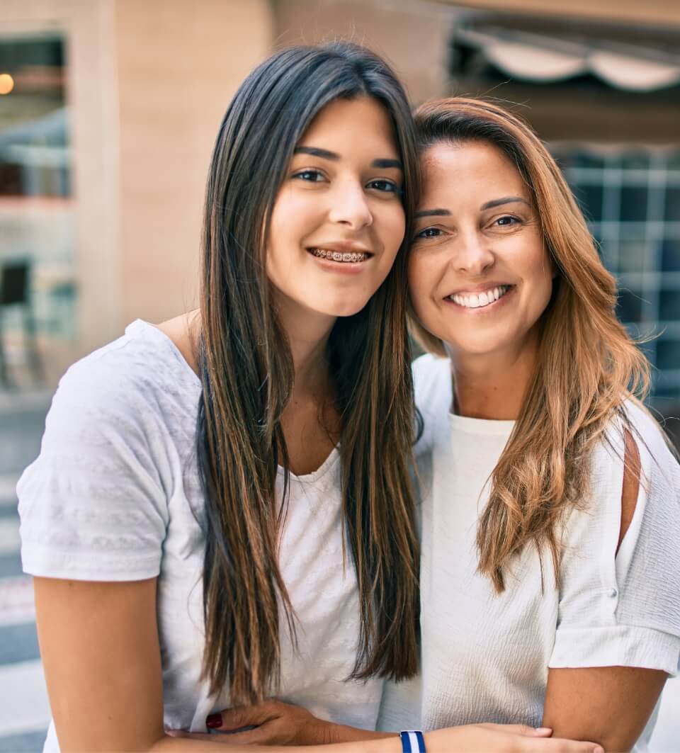 Mother smiling with her daughter after visiting the orthodontist