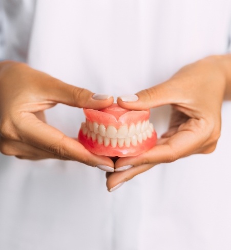 Dentist holding a denture