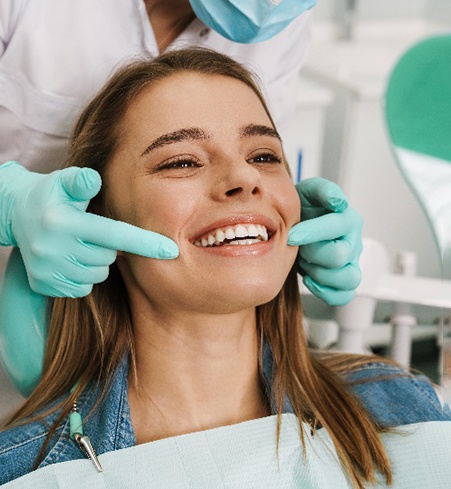 Young woman smiling at straight teeth in mirror