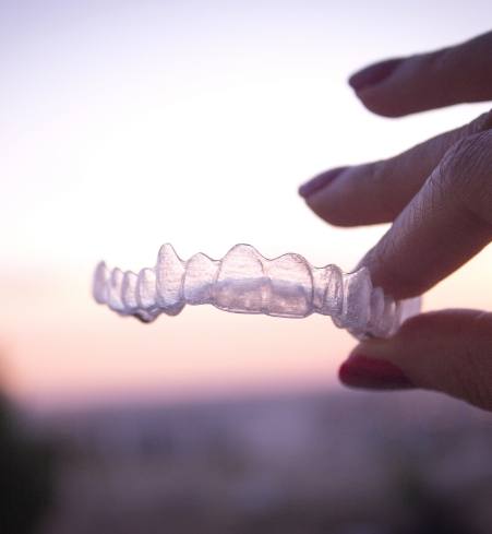 Patient holding an Invisalign tray