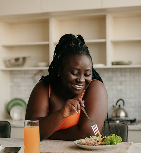 Woman smiling while eating lunch in kitchen