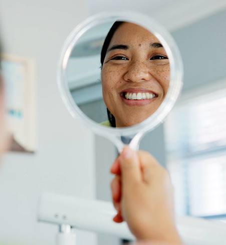 Patient smiling at reflection at mirror