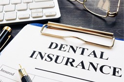 Dental insurance paperwork on desk next to supplies