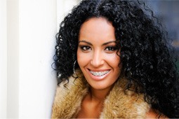 : Beautiful woman with black curly hair and braces smiling
